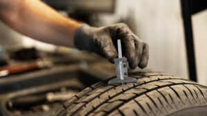 Mechanic checking tread depth on matching AWD winter tires during a North York tire inspection