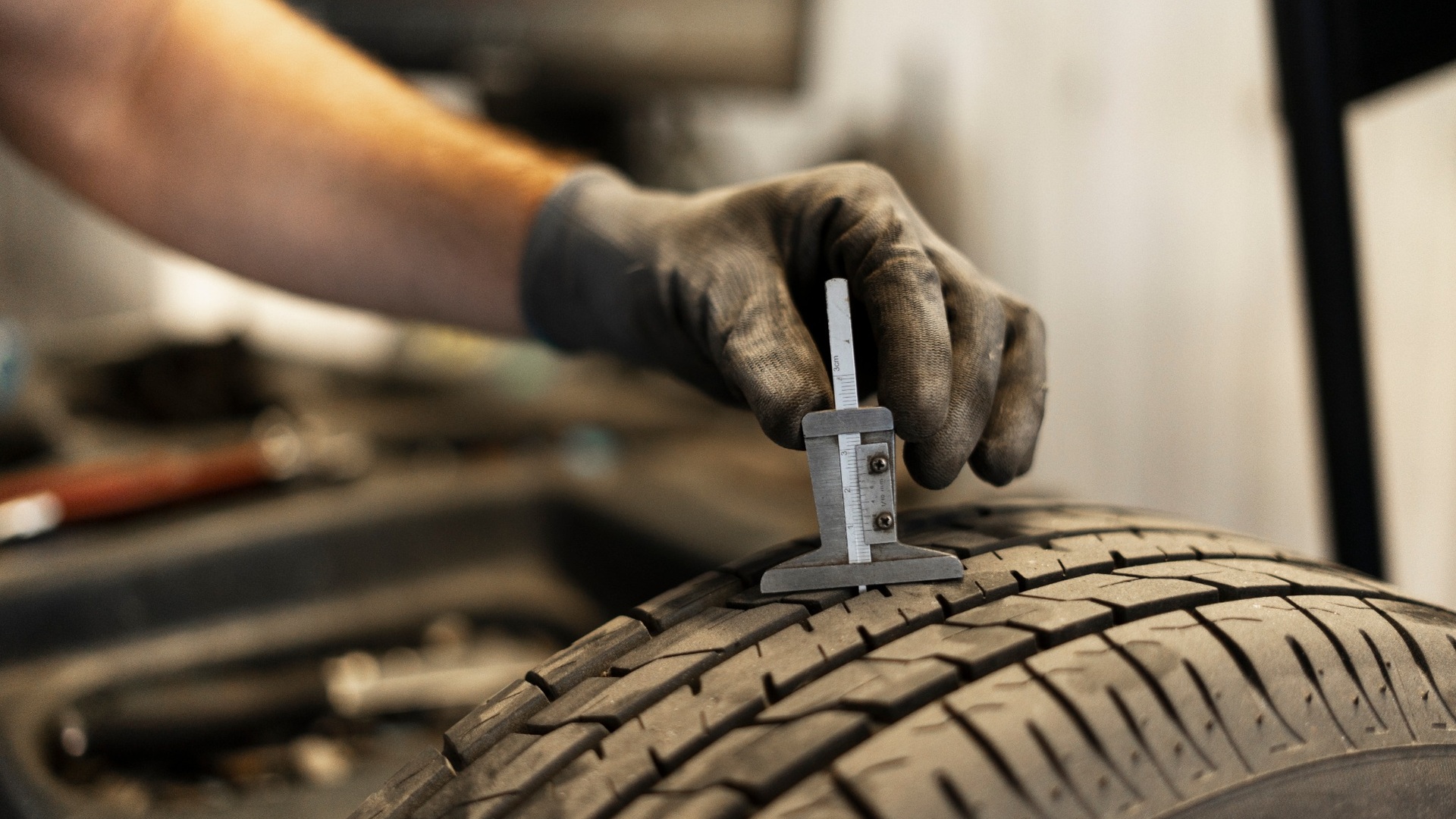 Mechanic checking tread depth on matching AWD winter tires during a North York tire inspection